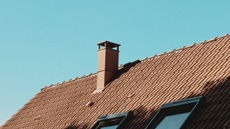 Detail of house roof with chimney and attic windows